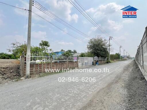 Spacious property exterior with clear skies and gated entrance