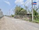 Exterior view of gated residential property with adjacent road