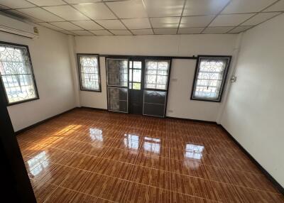 Spacious living room with polished wooden flooring and ample natural light