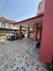 Carport with floral tile flooring and overhead roofing