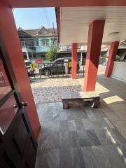 Open patio space with decorative tile flooring and vibrant red columns