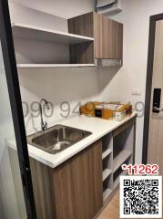 Modern compact kitchen with wooden cabinets and stainless steel sink