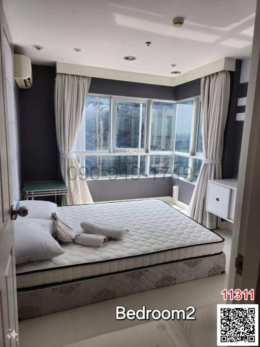 Spacious bedroom with large windows and modern furnishings