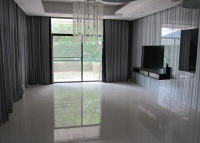 Spacious living room with a sleek modern design, large windows, and a view of the garden
