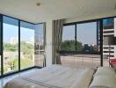 Modern bedroom with large windows overlooking the city