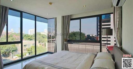 Modern bedroom with large windows overlooking the city