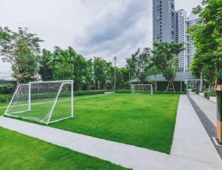 Spacious outdoor common area with green lawn and soccer goals