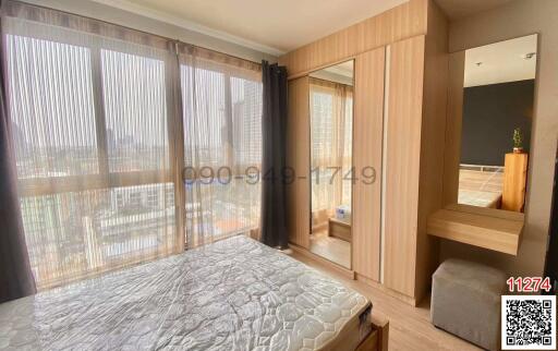 Spacious bedroom with large windows and city view