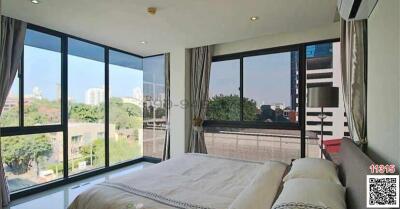 Modern bedroom with large windows and urban view