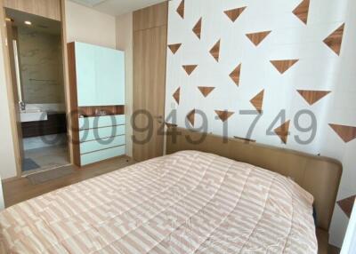 Modern bedroom with artistic wall design and adjoining bathroom