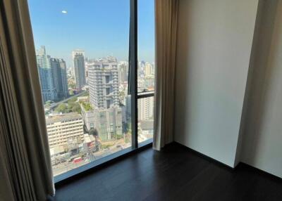 Modern urban bedroom with large window overlooking the city