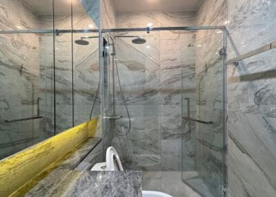 Modern bathroom with spacious glass shower and marble detailing