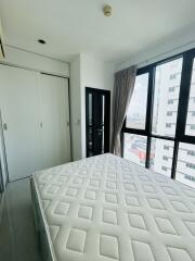 Modern bedroom interior with large window offering city views