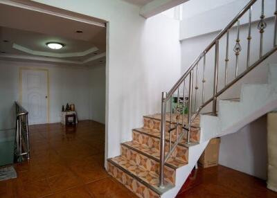 Spacious living area with staircase and ceramic tile flooring