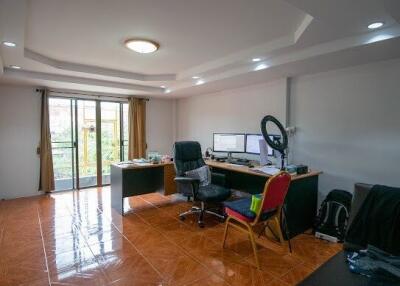 Spacious home office with large desk and natural light