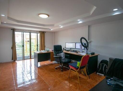 Spacious home office with large desk and natural light