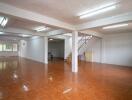 Spacious empty interior of a building with polished tile flooring and a staircase