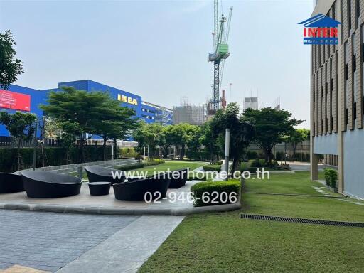 Spacious outdoor common area with landscaping and seating near residential buildings