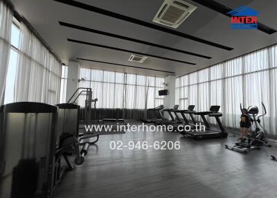 Spacious and modern gym with multiple exercise machines and floor-to-ceiling windows