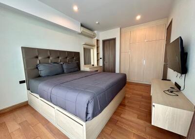 Modern bedroom with wooden flooring and contemporary furnishings