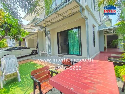 Modern white two-story house with spacious front yard and red pathway