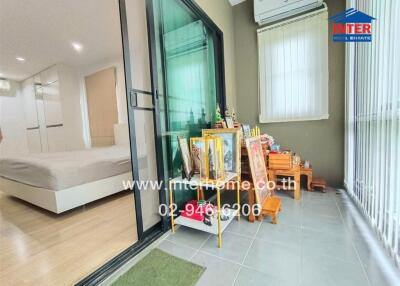 Spacious bedroom with modern design, large glass door leading to a balcony