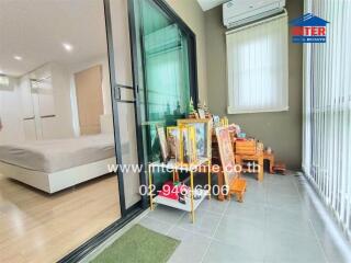 Spacious bedroom with modern design, large glass door leading to a balcony