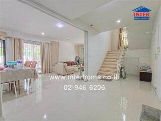 Spacious and well-lit living room with an open staircase