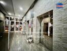 Modern building lobby with elegant stone wall design and multiple mirrored surfaces
