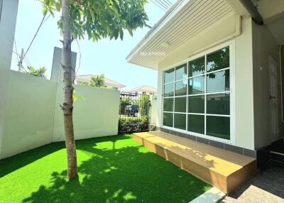 Modern home exterior with large windows and artificial grass