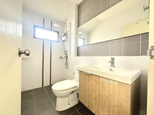 Modern bathroom with grey tiles and wooden cabinets