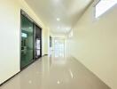 Bright and spacious hallway with glossy tiled flooring and ample natural light