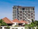 Modern high-rise residential building with a clear sky background