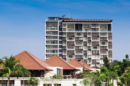 Modern high-rise residential building with a clear sky background