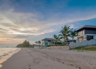 Serene beachfront property with modern homes during sunset