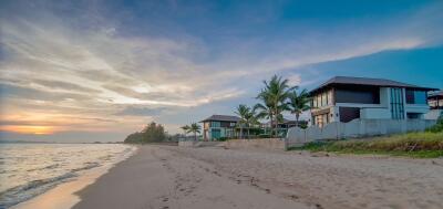 Serene beachfront property with modern homes during sunset