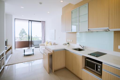 Modern kitchen with attached open living area featuring extensive natural light