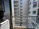 Apartment balcony overlooking other building units with washing machine and sunny city view