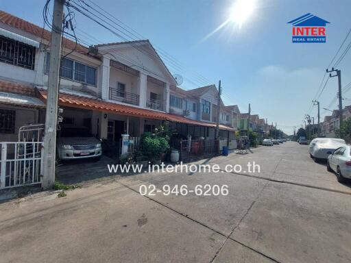 Townhouse row exterior view with parked cars and clear sky