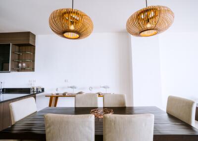 Modern kitchen with dining area featuring stylish pendant lights and a spacious wooden dining table