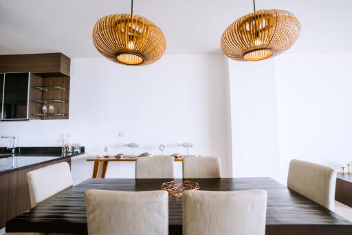 Modern kitchen with dining area featuring stylish pendant lights and a spacious wooden dining table