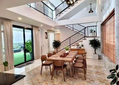Spacious dining room with modern staircase and open layout leading to a patio