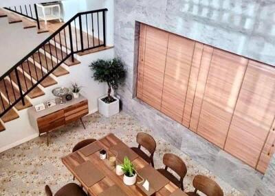 Elegant dining area with staircase and stylish wooden decor