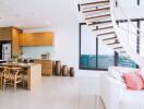 Modern open-plan living area with kitchen, dining, and lounge space, featuring staircase