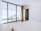 Spacious and modern bedroom with large glass doors leading to a balcony