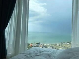 Bedroom with a view of the ocean through an open window