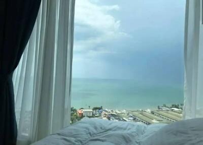 Bedroom with a view of the ocean through an open window