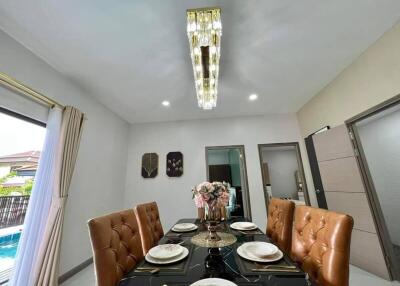 Elegant dining room with modern chandelier and pool view