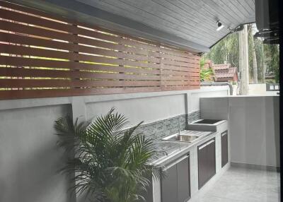 Modern outdoor kitchen with wooden accents and stainless steel appliances