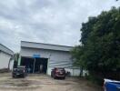 Exterior view of an industrial warehouse with vehicles parked outside